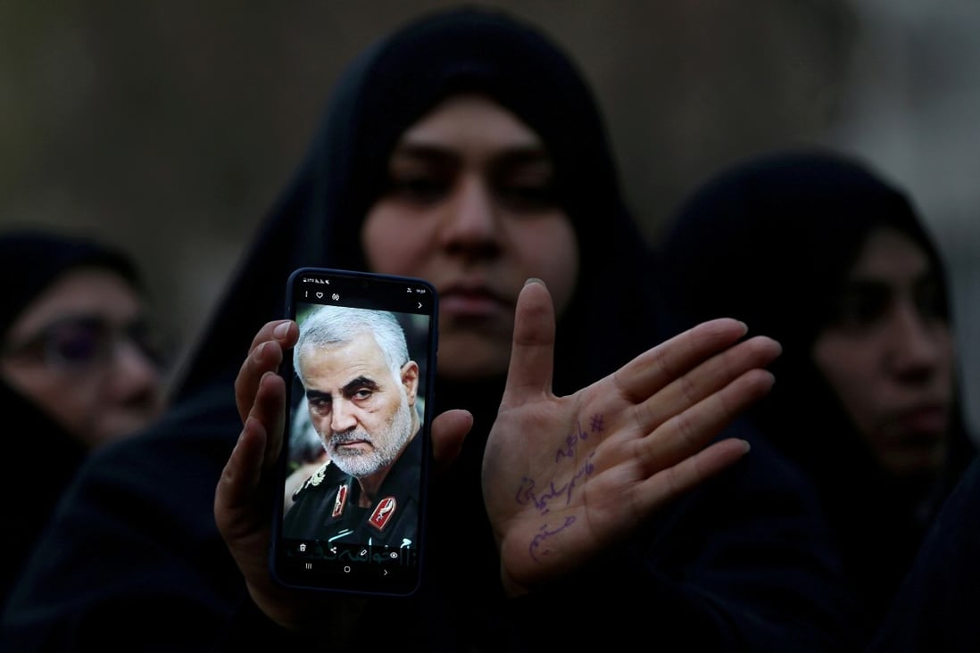 An Iranian woman shows a photo of the late Major General Qassem Soleimani during a protest against his assassination by the US. Photo: Reuters