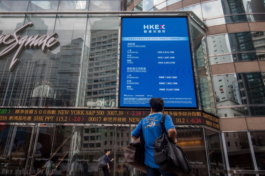 A pedestrian stands in front of an electronic ticker board and a screen displaying stock figures outside the Exchange Square complex, which houses the Hong Kong stock exchange, in Hong Kong on Monday, September 16, 2019. Photo: Bloomberg