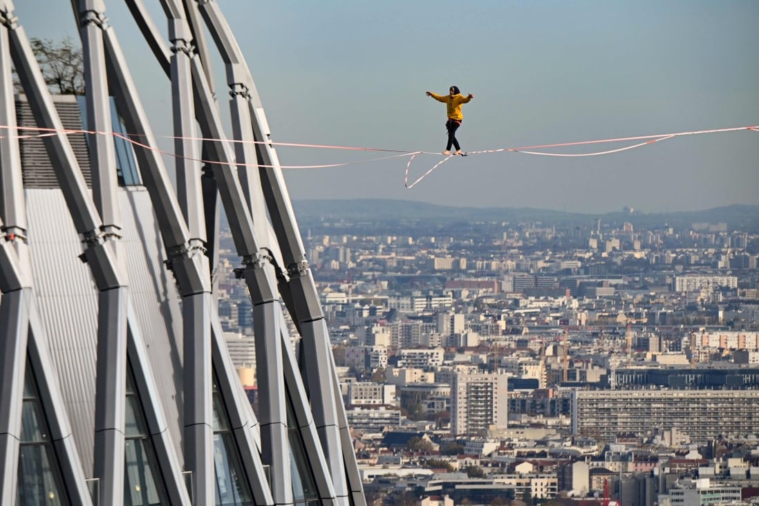 A tightrope walker performs above the business district of La Defense on the outskirts of Paris on November 22. The district has begun to attract robust foreign investment in real estate, including from South Korean investors. Photo: AFP