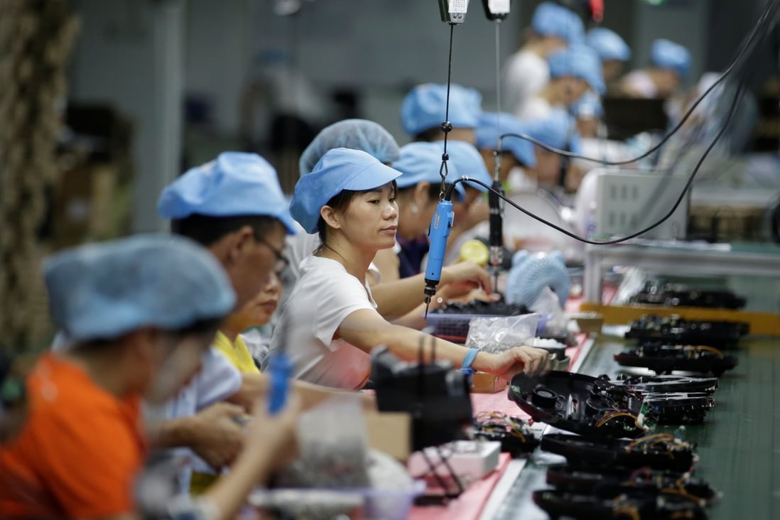 Employees work on the production line of a robot vacuum cleaner factory of Matsutek in Shenzhen, China. Photo: Reuters