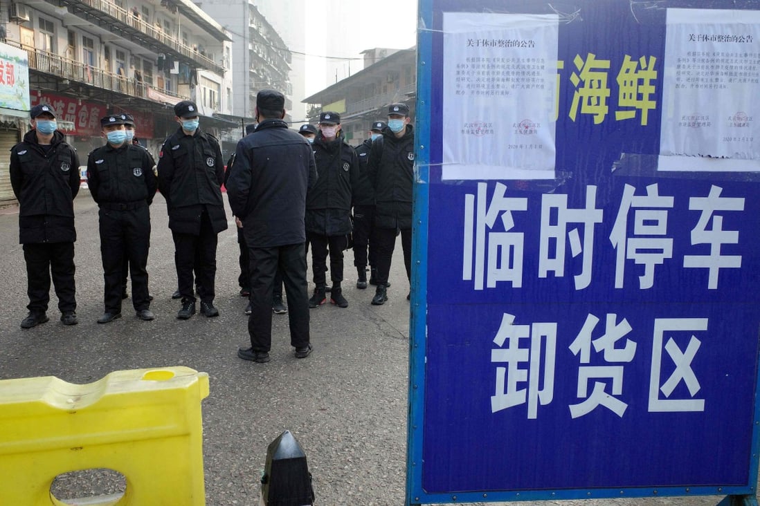 Security guards in front of the closed Huanan wholesale seafood market in Wuhan, China, this month, which the World Health Organisation said on Sunday was the source of most cases of the recent virus outbreak. Photo: AFP