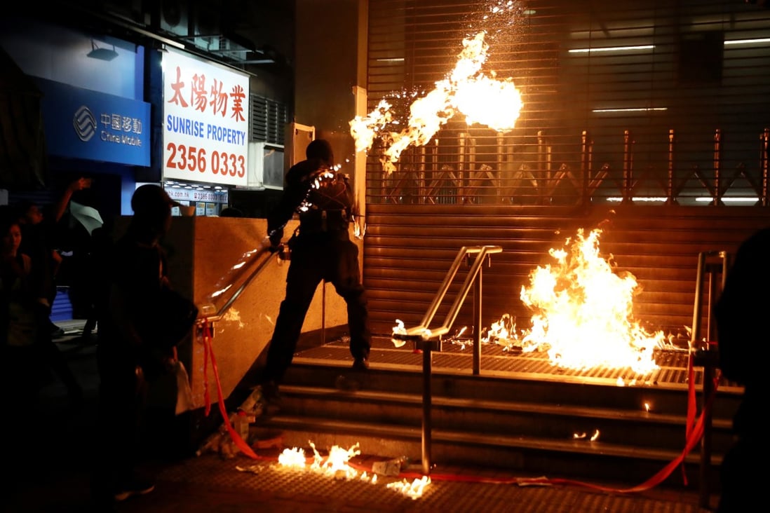 An anti-government protester throws a petrol bomb at Hung Hom MTR station during a rally on December 1. Photo: Reuters