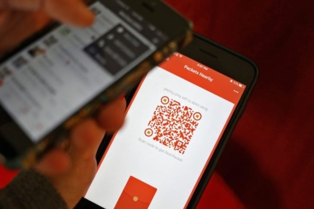 A WeChat user scans a QR code to retrieve a digital red envelope on the WeChat app on a mobile phone during the Chinese New Year period in Beijing in 2017. Photo: EPA/STR