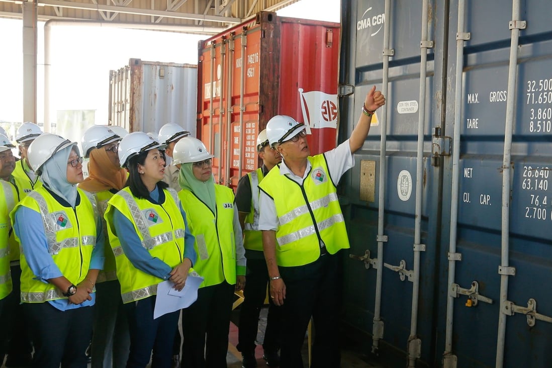 Malaysian Environment Minister Yeo Bee Yin (front 2nd L) and officials inspect a container. Photo: AFP