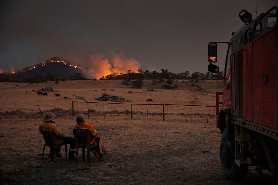Rural Fire Service volunteer firefighters watching as the New South Wales “megafire” approaches the outskirts of the town of Tumbarumba in New South Wales. Photo: Handout via AFP