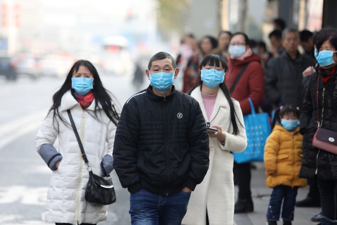 Chinese residents wear masks while waiting at a bus station near the closed Huanan Seafood Wholesale Market, which has been linked to cases of a new strain of Coronavirus. Photo: EPA-EFE