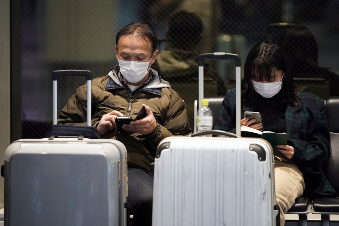 Travellers wear masks at the Tokyo International Airport on Wednesday. Photo: EPA-EFE