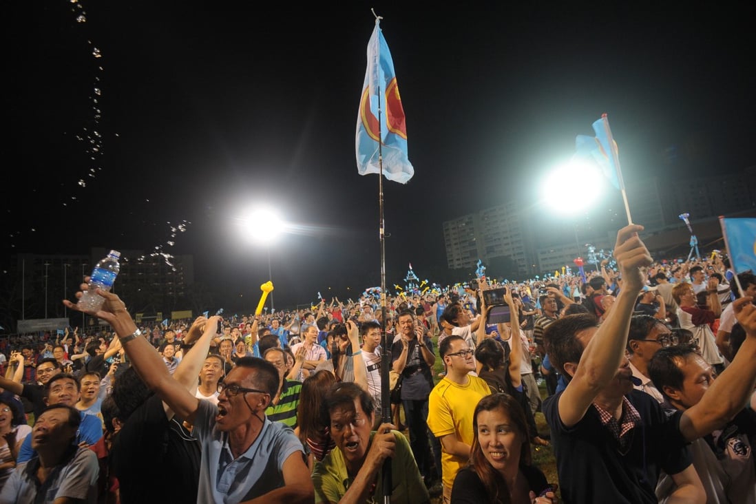 Workers’ Party supporters wave flags as they celebrate at Hougang Stadium in Singapore after general elections in September 2015. Photo: AFP