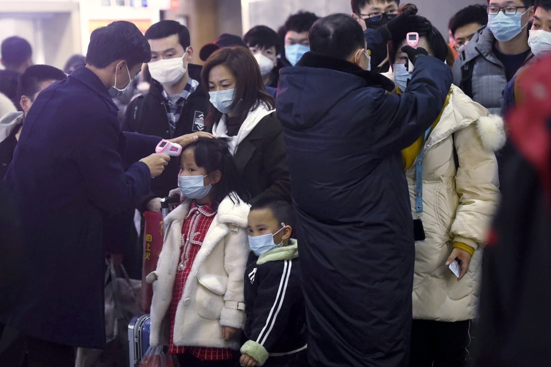Passengers from Wuhan go through temperature checks at a train station in Hangzhou on Thursday. Authorities say younger people are not considered highly susceptible to the virus. Photo: AP