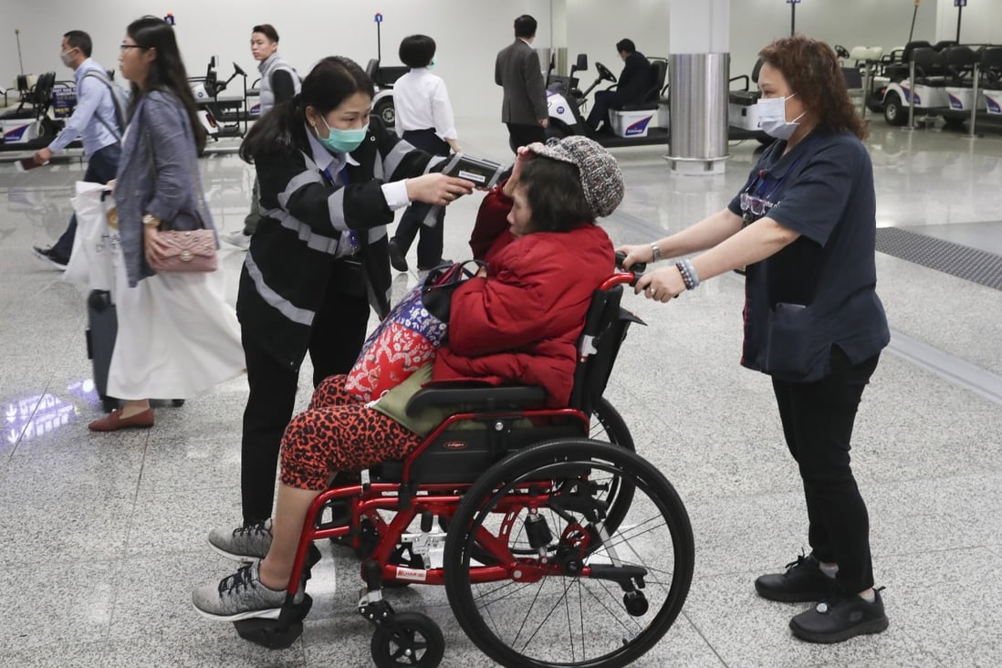 Health officials check the body temperatures of passengers arriving at Hong Kong airport on Thursday. Photo: AP