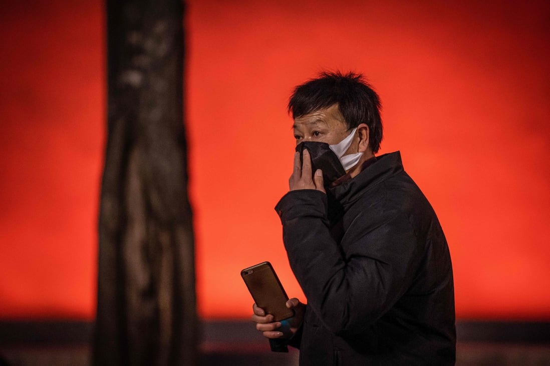 A man adjusts his protective mask near Tiananmen Gate in Beijing. A coronavirus fatality was reported on Thursday in Hebei province, near the capital city. Photo: AFP