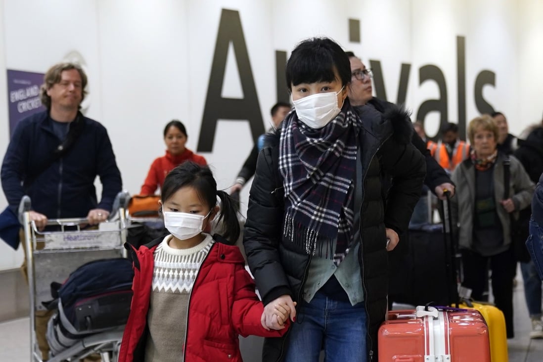 Passengers wear protective masks as they arrive at London’s Heathrow Airport. The first confirmed cases of the Chinese coronavirus were reported in Europe on Friday. Photo: EPA-EFE