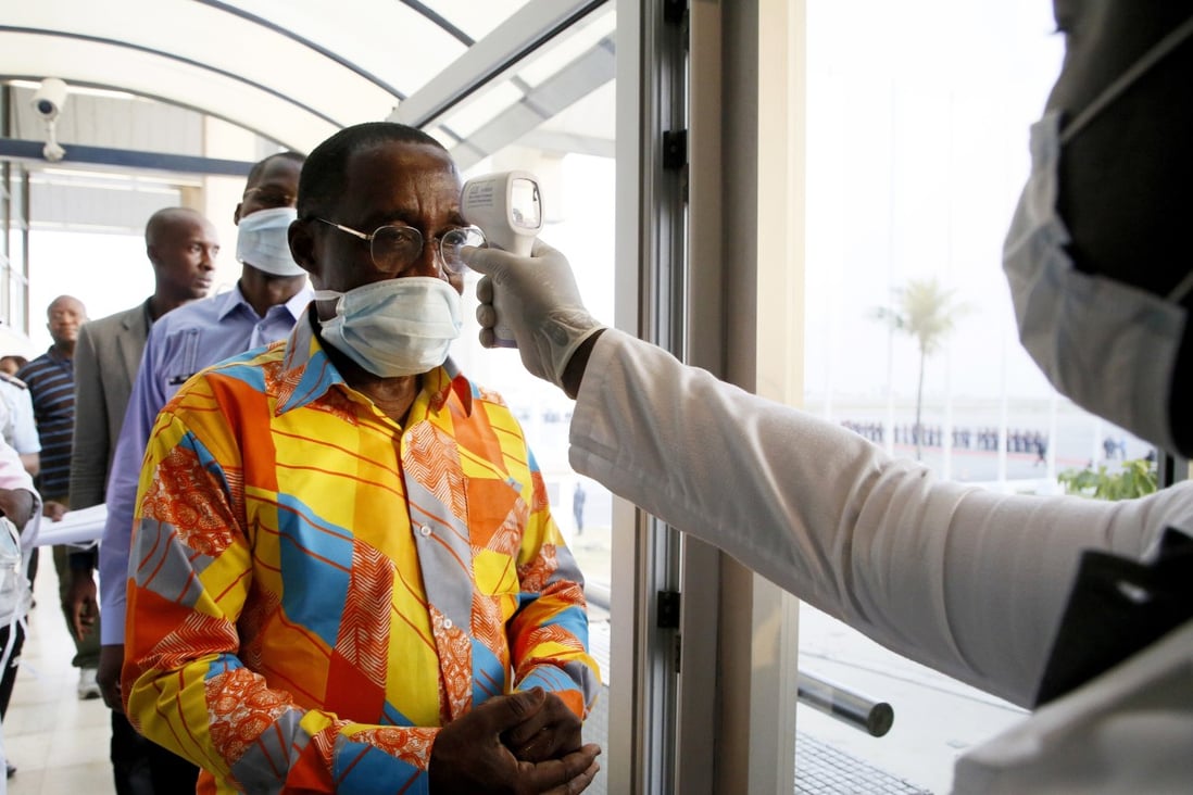 An Ivorian health worker checks the temperature of Ivorian Minister of Health and Public Hygiene Eugene Aka Aoule (left) as the country steps up screening for coronavirus at Felix Houphouet-Boigny Airport in Abidjan on Sunday. Photo: EPA-EFE