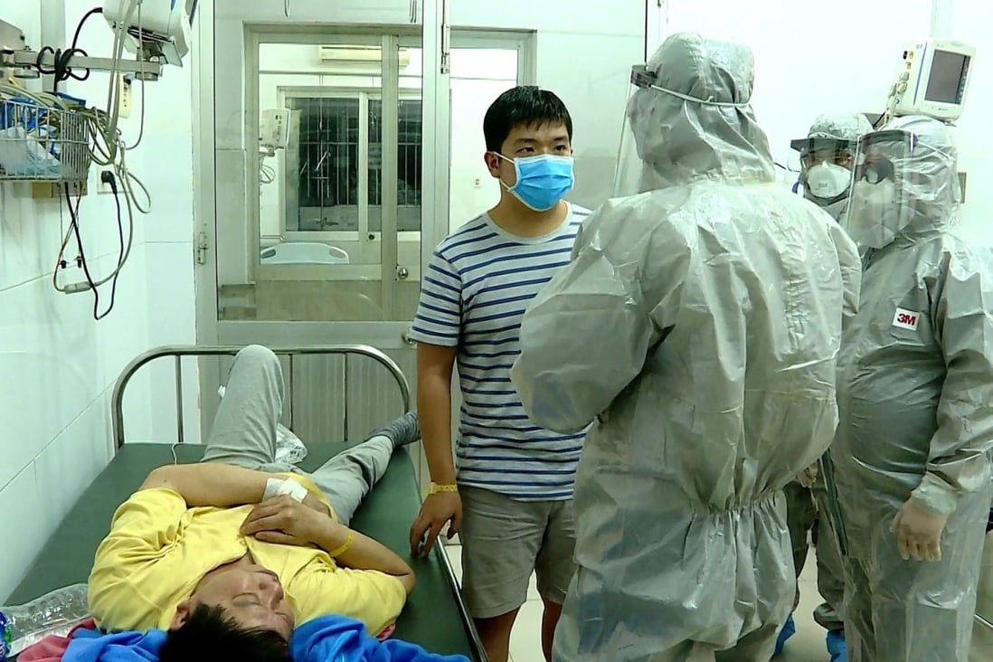 Officials from Vietnam’s Ministry of Health talk to the two men who tested positive for the coronavirus. Photo: EPA
