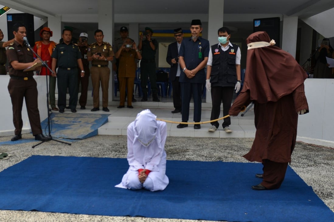 A female flogger whips an unmarried woman who was caught with a man in a hotel, on December 10, 2019, in Banda Aceh. Photo: AFP