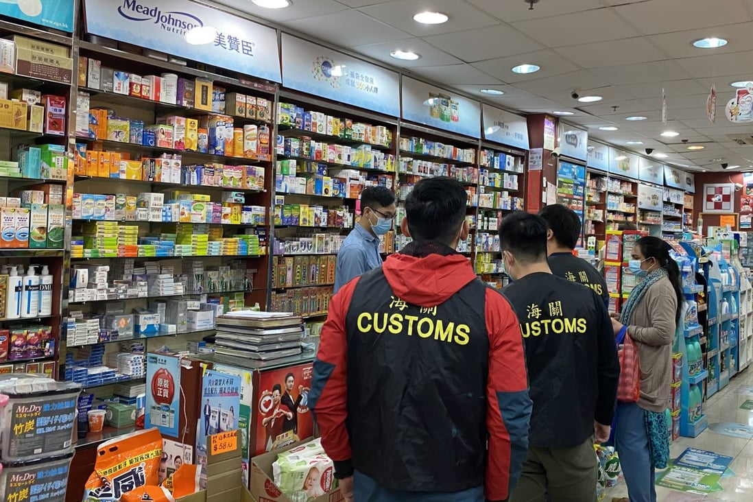 Hong Kong customs officers conduct a spot check on a store selling surgical masks. Photo: Handout