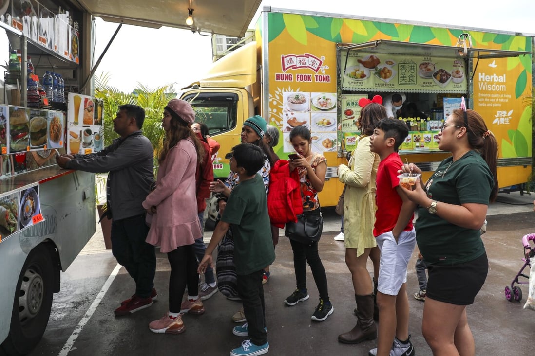 People queue for food in front of a food truck in Hong Kong Disneyland. Photo: Xiaomei Chen