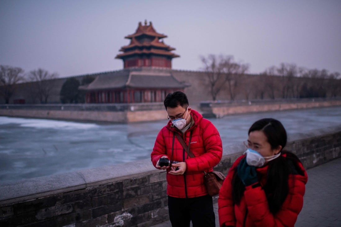 A couple walk near the deserted Forbidden City in Beijing this week. The coronavirus is rapidly spreading. Photo: AFP