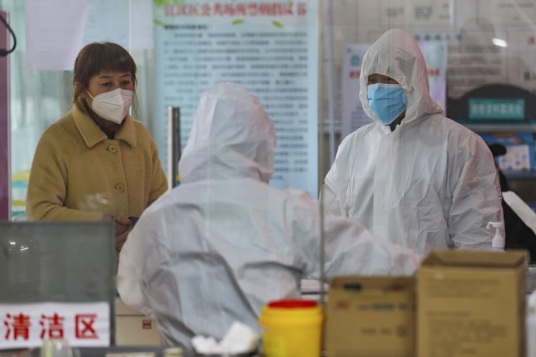 Medical workers in Wuhan assess a woman suspected of having the coronavirus on Monday as efforts to contain the disease continued. Photo: AP