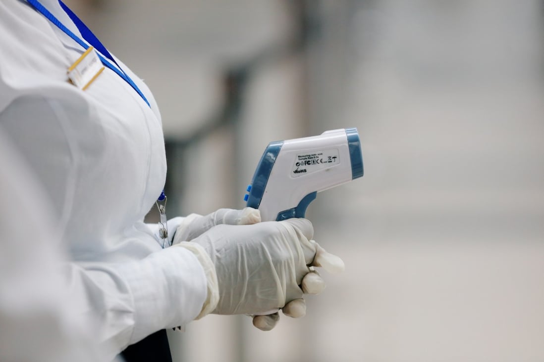 A health worker holds a thermometer as she waits to screen travellers for signs of the coronavirus at the Kotoka International Airport in Accra, Ghana, on Thursday. Photo: Reuters