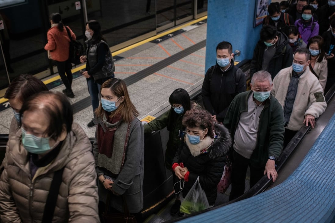 Mask-wearing passengers board an escalator at Kowloon Tong station on January 30. Photo: Bloomberg