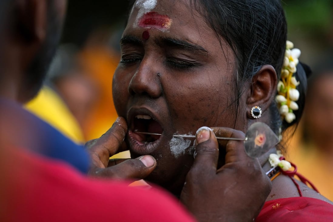 A Hindu devotee having a skewer pierced into her cheek during the Thaipusam festival at Malaysia’s Batu Caves. Body piercers claim they can perform such piercings and much more without causing pain and even without blood. Photo: Getty