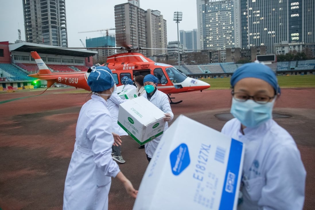 Staff of Concorde hospital transfer medical supplies from a helicopter in Wuhan. Photo: EPA-EFE