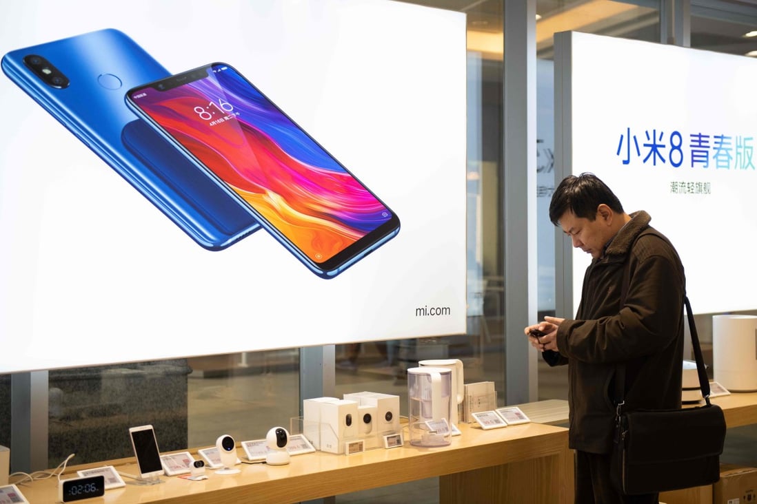 A man looks at a mobile phone in a Xiaomi shop in Beijing. File photo: AFP