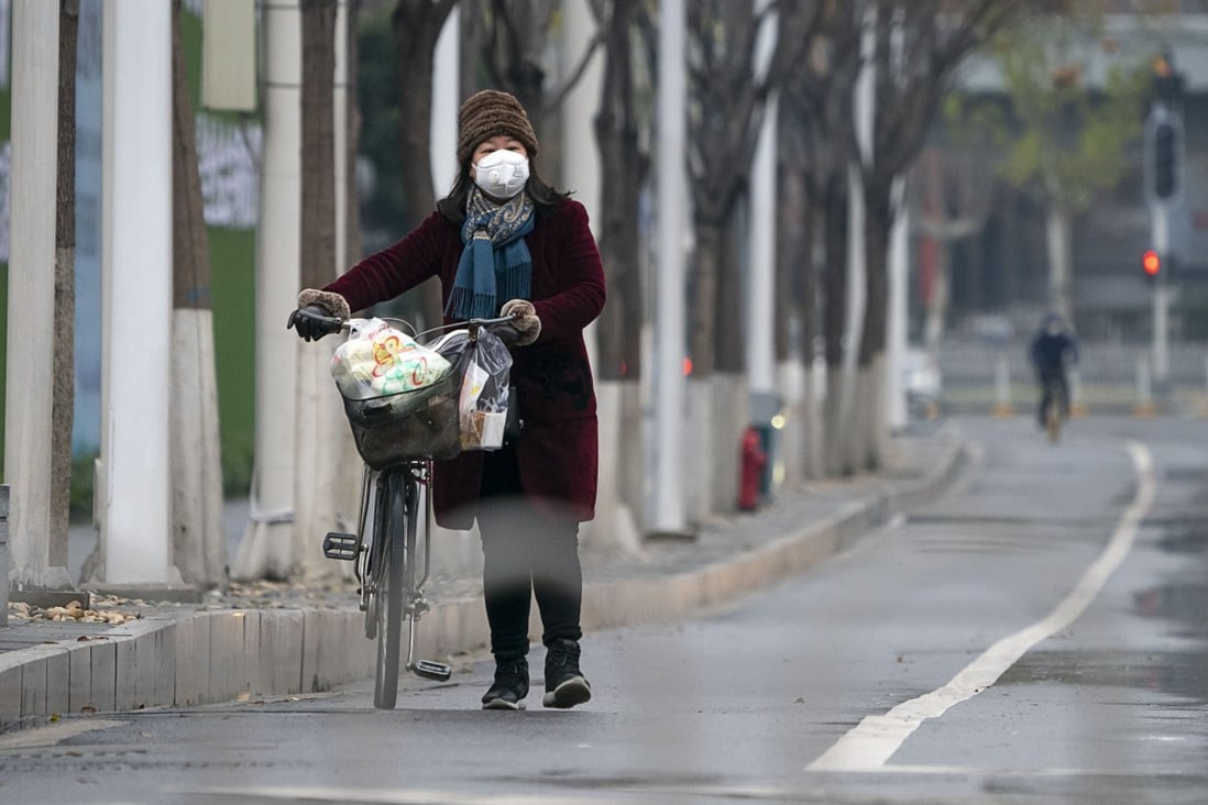 A woman in a protective mask walks along a street in Wuhan, the epicentre of the coronavirus outbreak. Photo: Xinhua