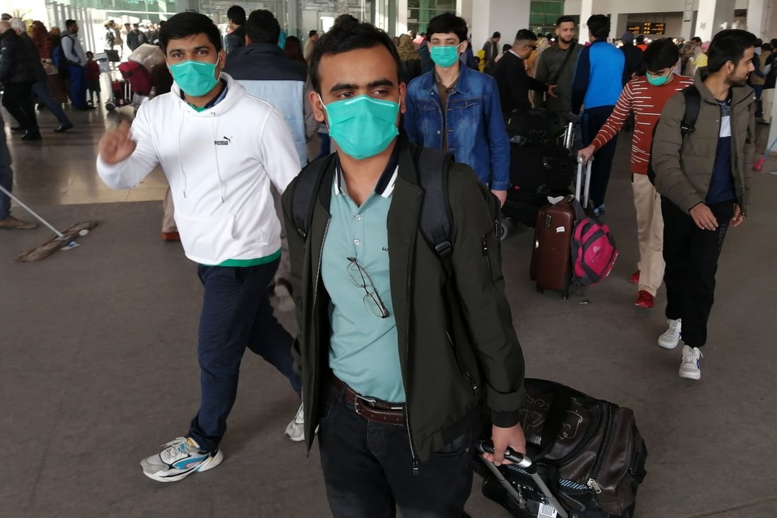 Pakistani students wearing protective face masks arrive at Islamabad International Airport on a flight from China on Monday. Photo: AFP