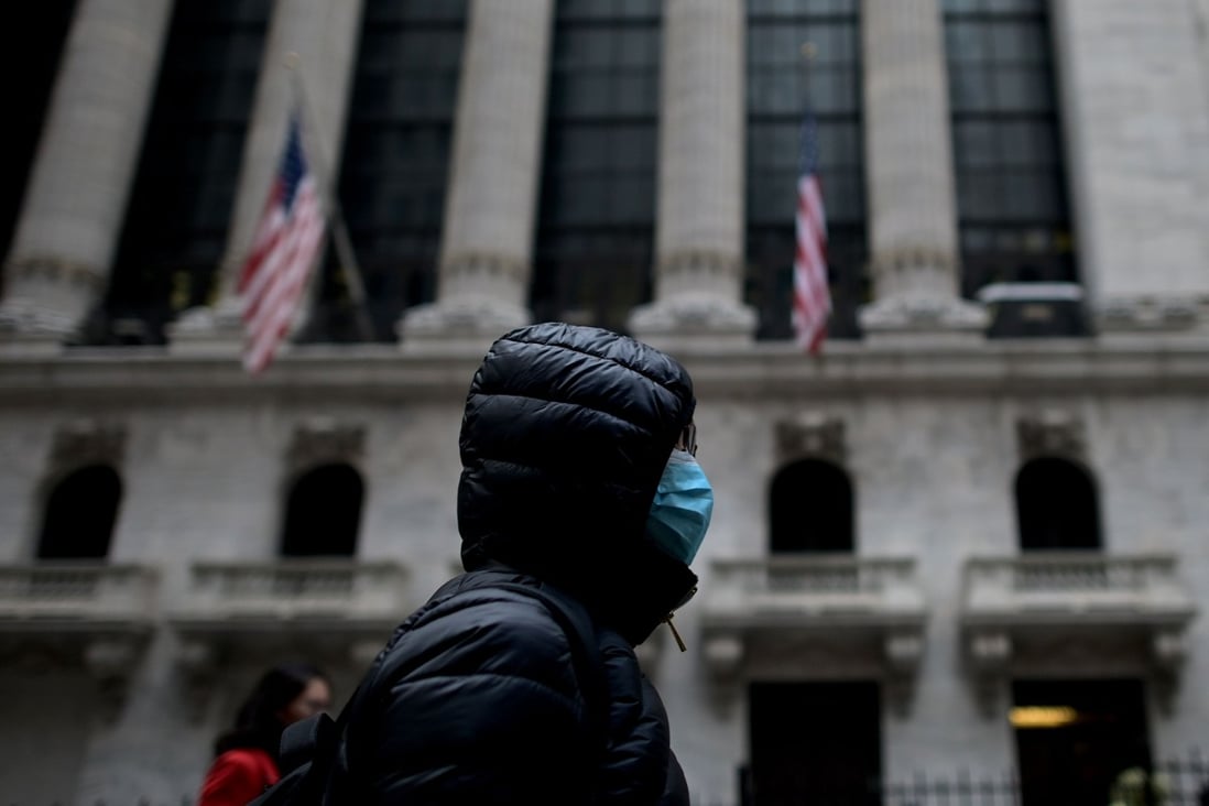 A woman wearing a protective mask passes the New York Stock Exchange on Monday. The US says its offer to join a World Health Organisation mission to China to fight the coronavirus has been accepted. Photo: AFP