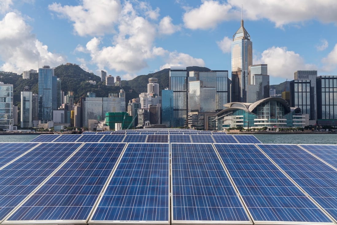 Solar panels are flanked by the Hong Kong skyline. It is already possible to reduce emissions from cities by 90 per cent using proven low-carbon measures such as solar power, mass transit and improved recycling. Photo: Shutterstock