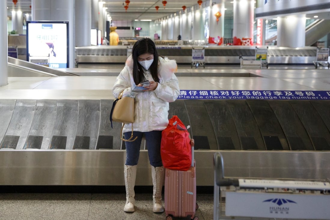 A woman checks her phone at an empty luggage collection hall at the airport in Changsha, Hunan province. The Cyberspace Administration of China has clamped down on online media platforms in a bid to maintain social stability amid the coronavirus crisis. Photo: Reuters
