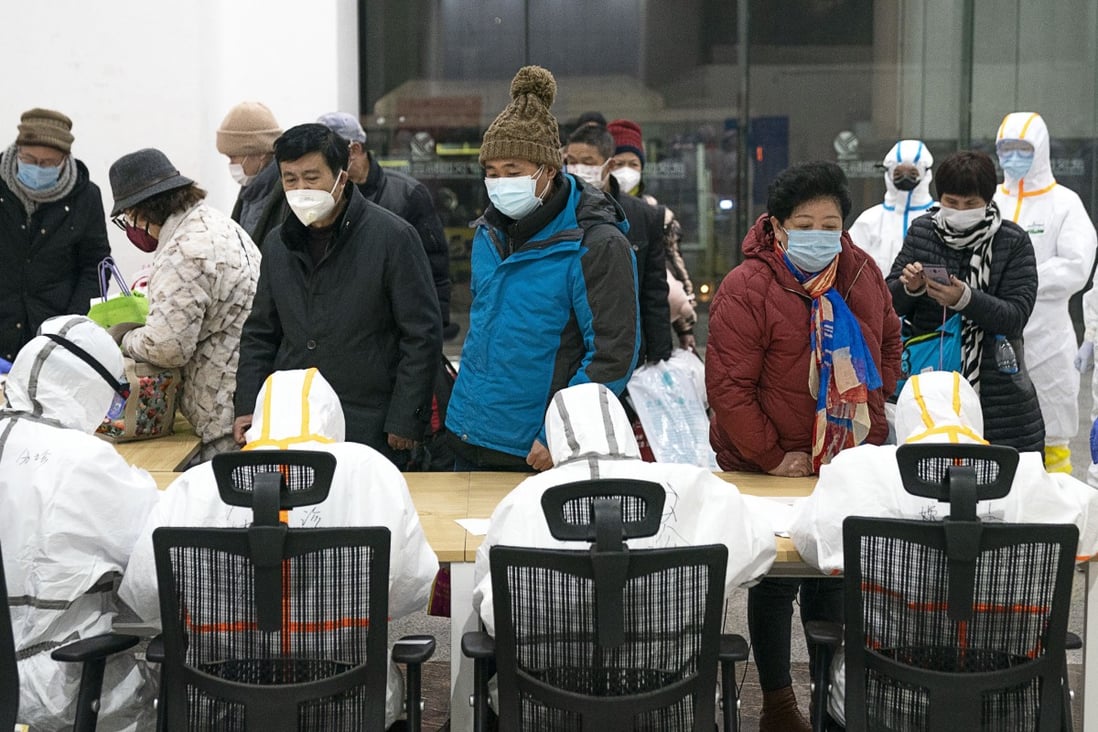 Medical workers in Wuhan help patients infected with the novel coronavirus check in at a makeshift hospital, converted from an exhibition centre, on Wednesday. Photo: Xinhua