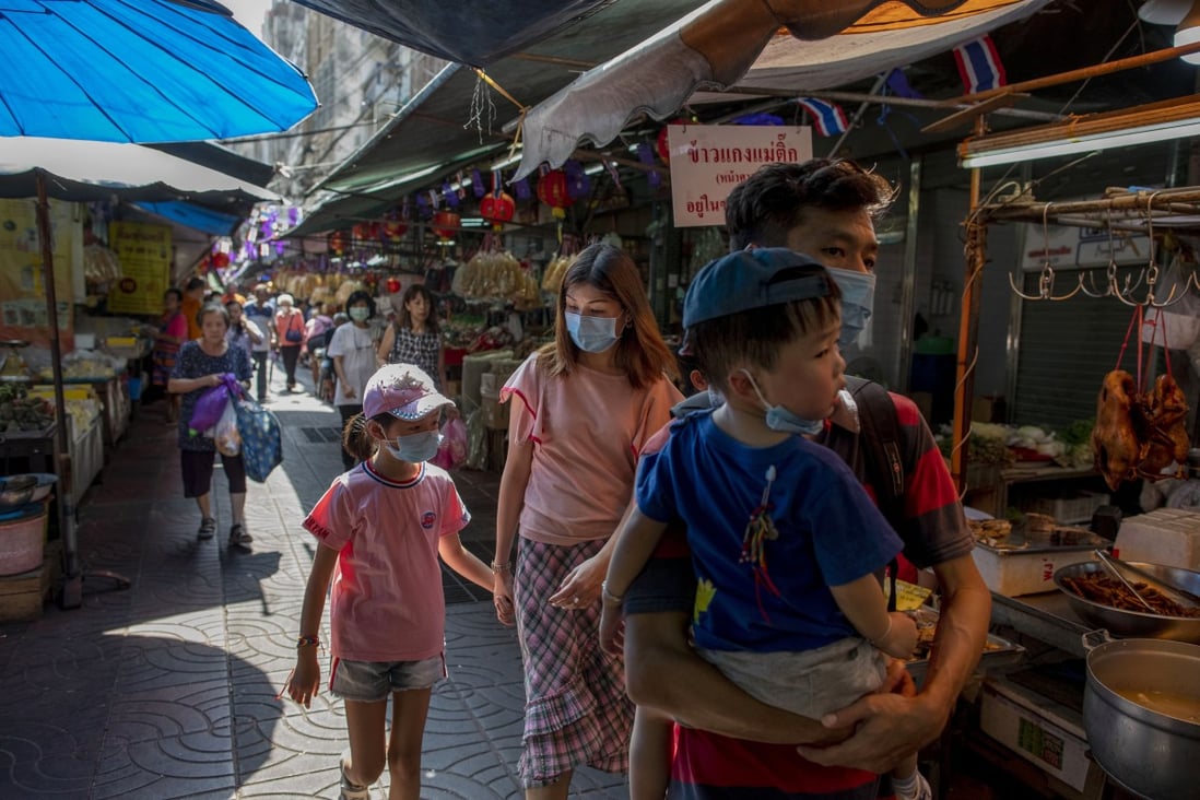 Tourists walk through Bangkok’s Chinatown. Thailand’s central bank has cut its benchmark interest rate to help the economy weather the virus outbreak in China that has devastated its tourism sector. Photo: AP