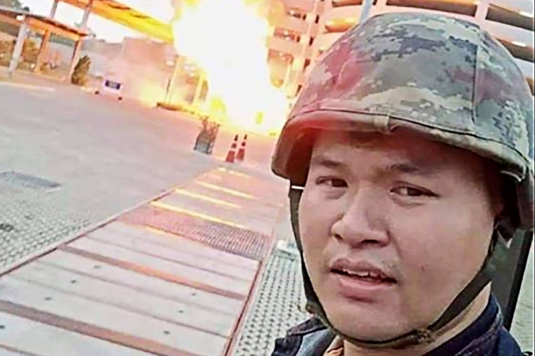 A screenshot from Jakrapanth Thomma’s Facebook live stream shows him standing in front of a building on fire in the city of Nakhon Ratchasima on Saturday. Photo: Facebook via AFP