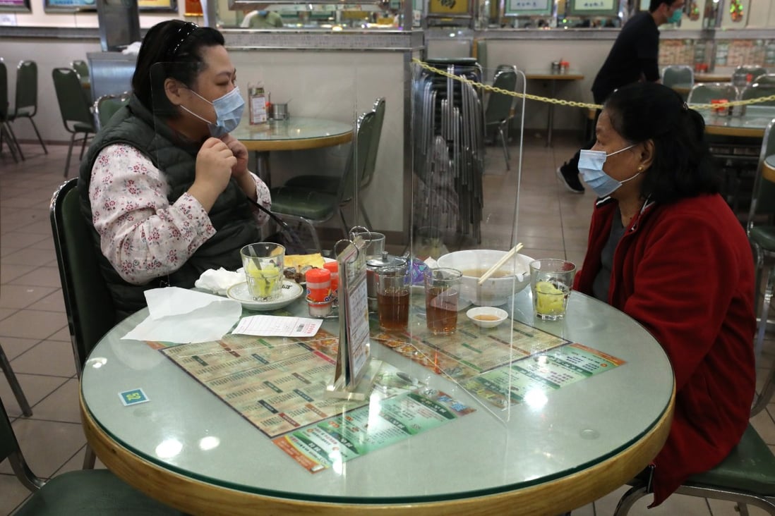 A perspex wall divides two diners who know each other at a cha chaan teng in Tai Kok Tsui in Kowloon. Photo: Nora Tam