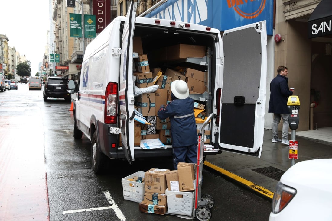 A US Postal Service worker unloads packages on December 2 in San Francisco. Photo: Getty Images via AFP