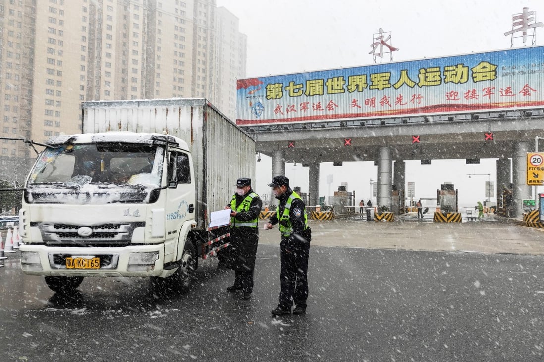 Traffic police officers check a vehicle at a toll station in Wuhan, Hubei province, on Saturday. Photo: Xinhua