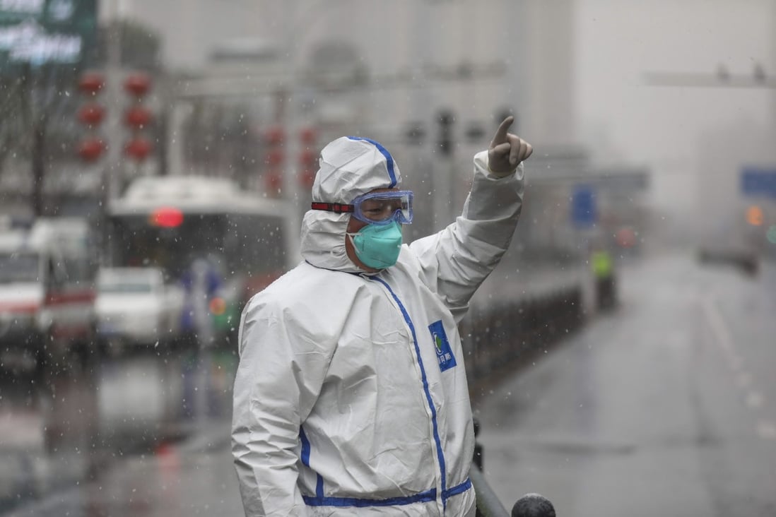 A worker directs vehicles arriving at a hospital newly designated to treat coronavirus patients in a wintry Wuhan. Photo: AP