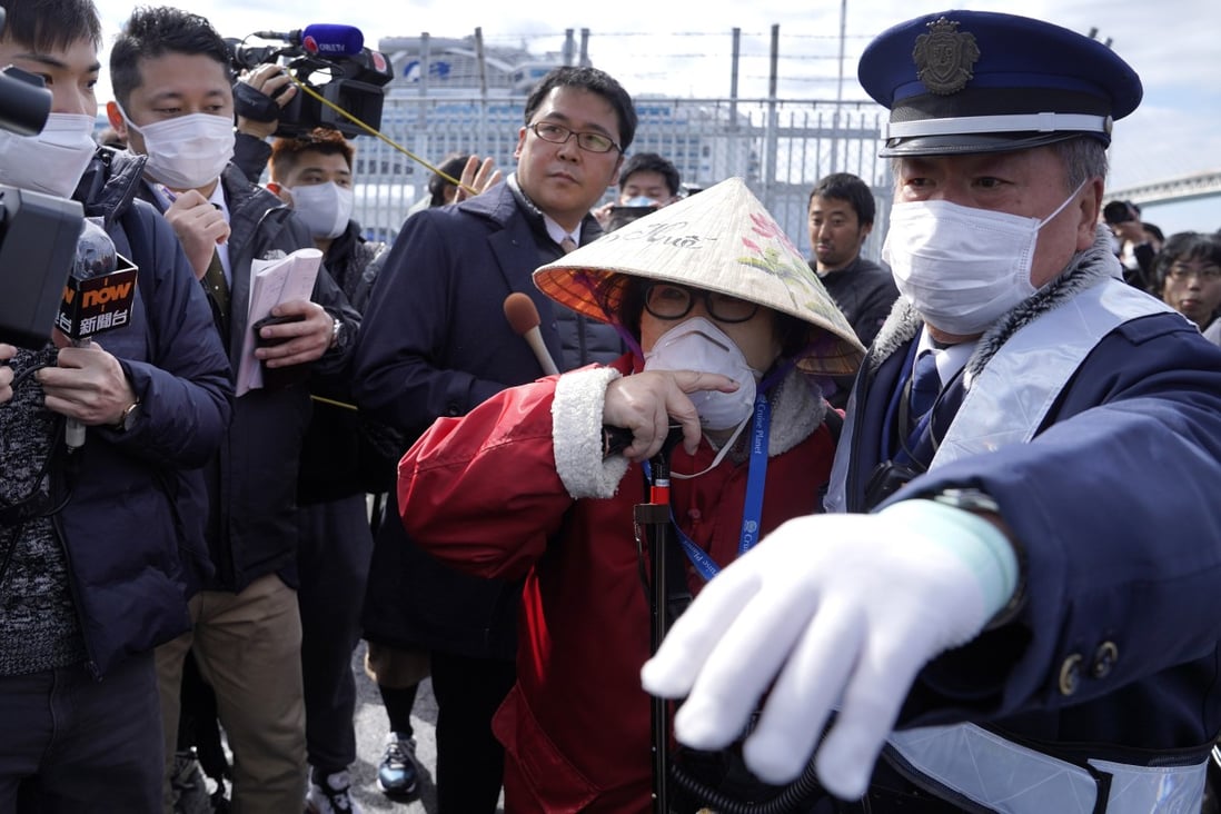 A passenger is surrounded as she disembarks the Diamond Princess cruise ship in Yokohama, Japan. Photo: EPA