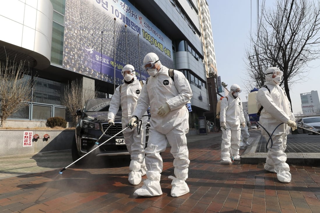 Workers wearing protective gear spray disinfectant in Daegu, South Korea, as cases of the new coronavirus surge. Photo: AP