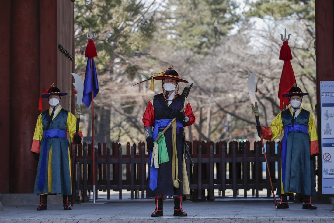 Workers in traditional outfits, along with surgical masks, at a palace in Seoul, South Korea. A coronavirus outbreak in the country has worsened in recent days. Photo: AP