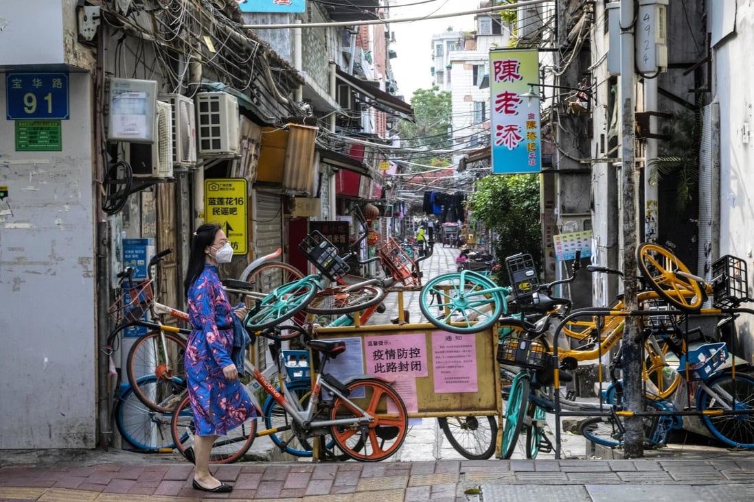 A woman wearing a mask walks past a road blockade made mostly of shared bicycles in Guangzhou, Guangdong province, on February 24. Although regions less affected by the coronavirus, such as Guangdong, have resumed work faster after the Lunar New Year holiday, businesses are still far from operating at full capacity. Photo: EPA-EFE