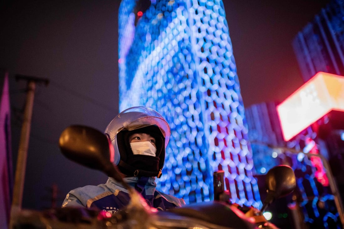 A delivery worker wearing a protective face mask at a red light in Beijing. Photo: AFP