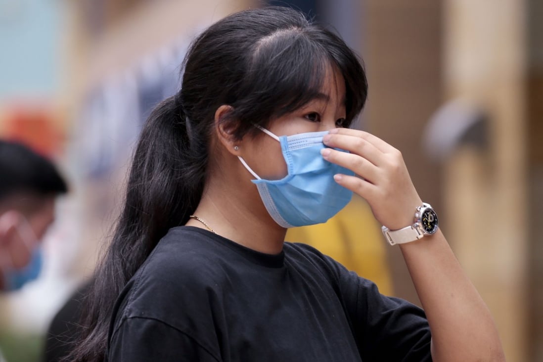 A woman in Sentosa, Singapore, adjusts her face mask, on February 21. An advisory issued by four doctors in Singapore urging the public to wear face mask when going out was refuted by the Singapore Ministry of Health. Photo: EPA-EFE