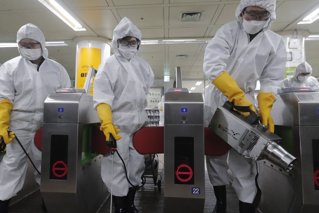 Workers in protective gear spray disinfectant at a subway station in the South Korean capital Seoul. Photo: AP