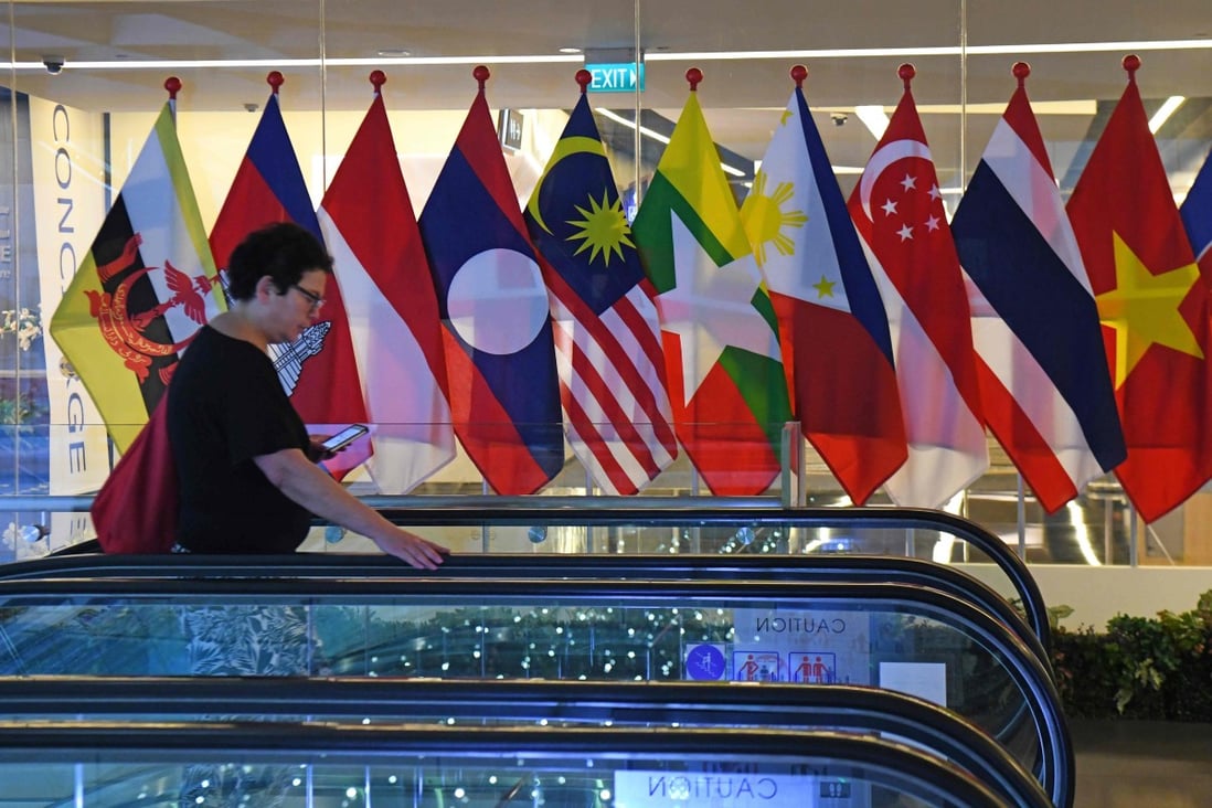 A woman walks past the national flags of Asean countries at the Suntec City convention and exhibition centre in Singapore in November 2018. Photo: AFP