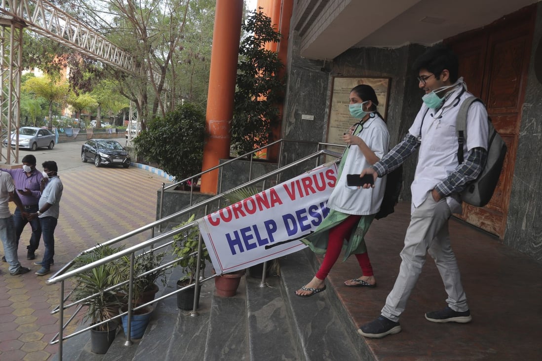 Doctors walk past the entrance of the coronavirus isolation ward at the Government Gandhi Hospital in Hyderabad, India. Photo: AP