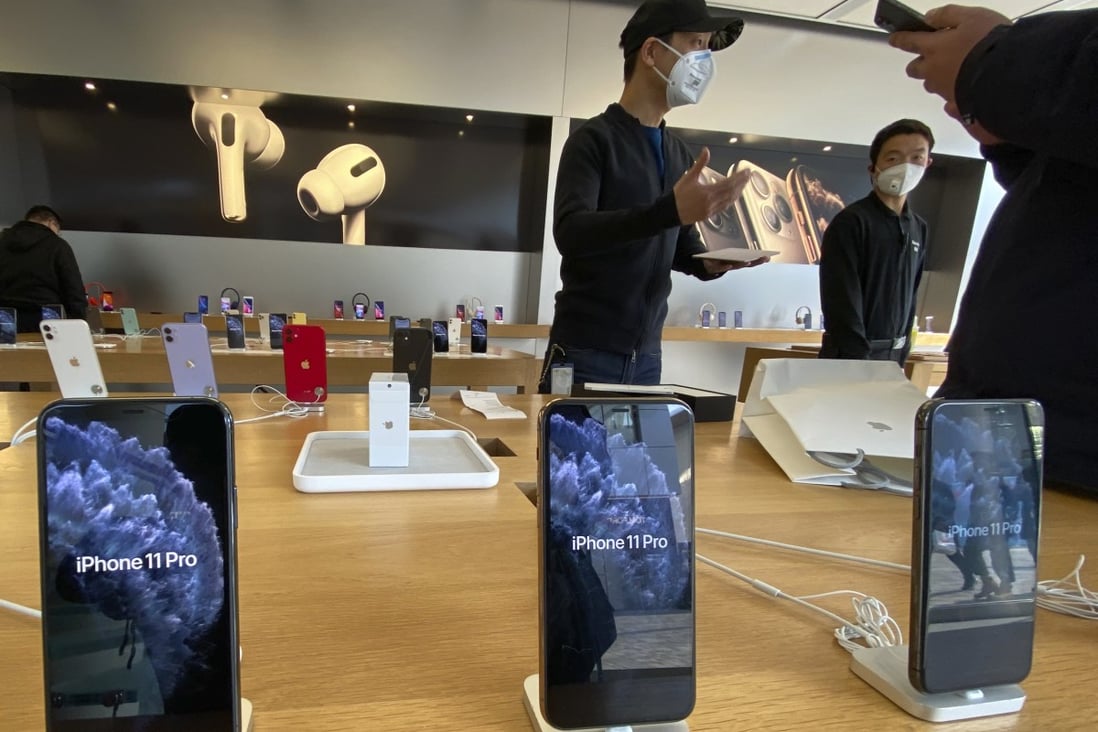 A staff member chats with customers at an Apple Store in Beijing on February 19. Factories that make the world's smartphones, toys and other goods are struggling to reopen after the novel coronavirus outbreak idled China's economy. Photo: AP